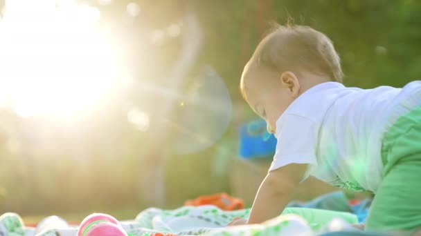 可爱的白人男婴站在花园的四个人前 背对着摄像机 可爱的孩子在阳光下玩玩具锤 — 图库视频影像