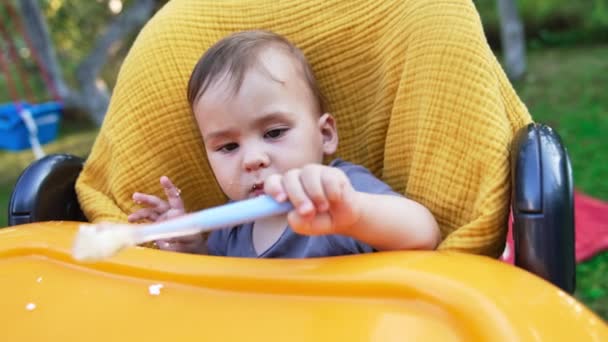 Menino Caucasiano Sentado Cadeira Alimentação Amarela Criança Pequena Com Cara — Vídeo de Stock