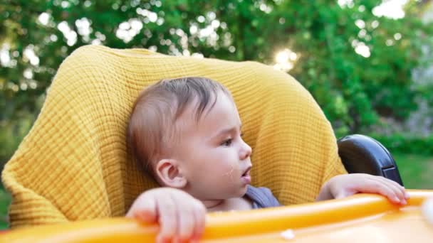 야외에서 노란색 의자에 사랑하는 엄마는 숟가락에서 그녀의 아들에게 클로즈업 — 비디오