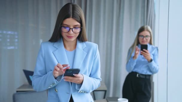 Smartfony Rękach Młodych Pracownic Urzędujących Długowłose Panie Okularach Trzymające Słuchawki — Wideo stockowe