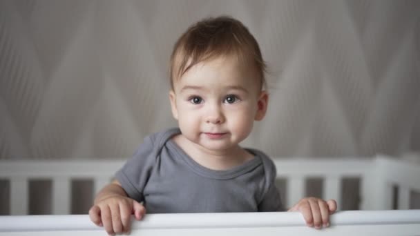Adorável Menino Sorridente Berço Branco Balançando Pouco Criança Sorri Docemente — Vídeo de Stock