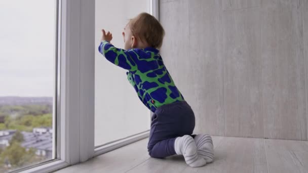 Кавказький Хлопчик Грає Підлозі Біля Великого Вікна Тодлер Стукає Вікно — стокове відео
