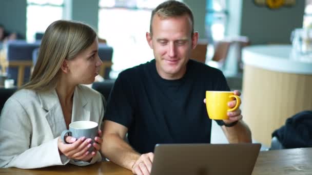 若い夫婦はカフェでコーヒーを楽しみ おしゃべりを楽しんでいる コミュニケーションをとり 仕事と休息を組み合わせる配偶者 クローズアップ — ストック動画