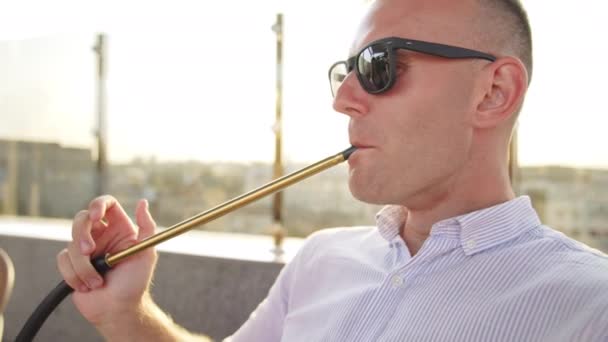 Sebevědomý Uvolněný Muž Slunečních Brýlích Kouřící Dýmku Dívající Svůj Telefon — Stock video