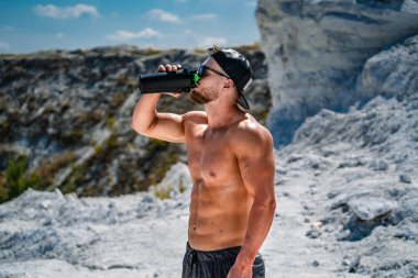 Kaslı adam idmandan sonra su içiyor..