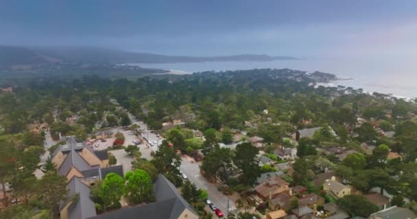 カルメル カリフォルニア アメリカの美しい海洋都市の上に劇的な暗い嵐の空 木の上に低く飛ぶドローン — ストック動画