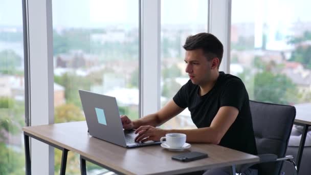 Jovem Homem Focado Trabalhando Laptop Escritório Homem Toma Uma Chávena — Vídeo de Stock