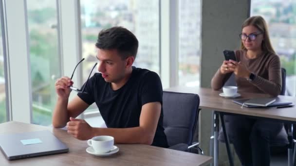Brunet Männlicher Angestellter Setzt Seine Brille Auf Und Öffnet Laptop — Stockvideo