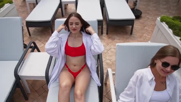 Entspannte Mädchen Legen Sich Auf Die Liegestühle Blonde Und Brünette — Stockvideo