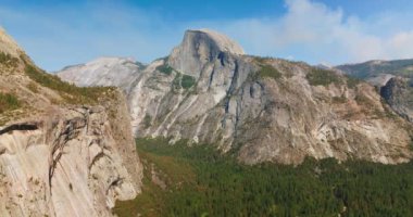 Çam ağaçlarının üzerinde yükselen gri kayalar. Kaliforniya 'daki Yosemite Ulusal Parkı güneşli bir günde.