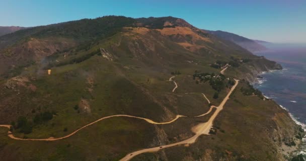 山坡上的高速公路和人行道 从空中看阳光灿烂的加利福尼亚岩石海岸 — 图库视频影像