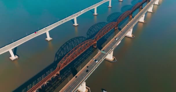 一方向の高速道路を備えた美しいシンプルな橋 橋で移動する複数の車両 中央に金属アーチ鉄道橋 — ストック動画