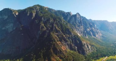 Dev kayaların güneşli tarafını kaplayan çam ağaçları. Yosemite Ulusal Parkı 'ndaki çarpıcı dağlar, Kaliforniya, ABD.