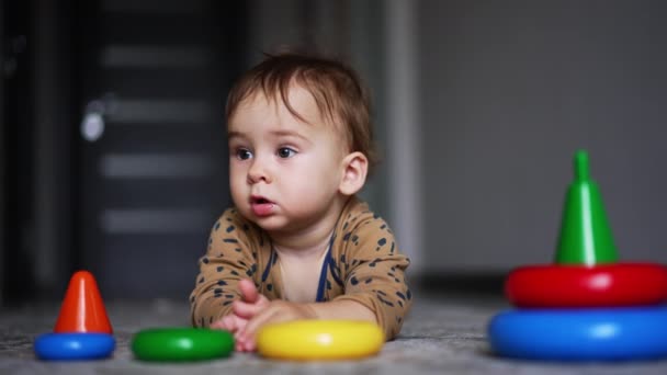 Ein Einjähriges Kind Liegt Auf Dem Boden Und Spielt Mit — Stockvideo