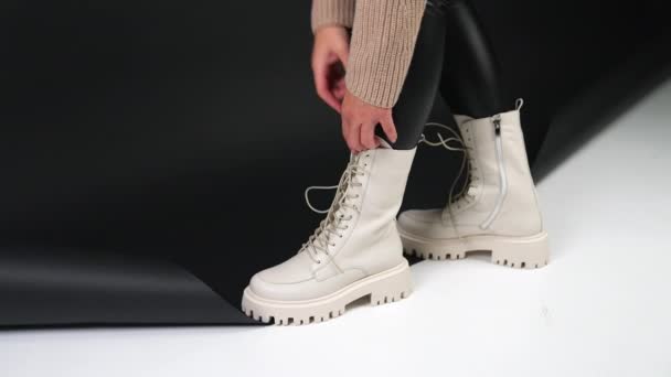 雌性在拖鞋鞋底的白色靴子处拉扯并握住舌头 展示现代秋鞋的模型 — 图库视频影像
