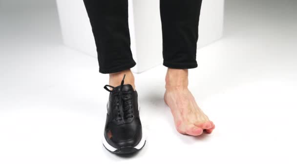 Мужские Ноги Ноги Ботинке Босиком Человек Сидящий Белом Стуле Двигает — стоковое видео