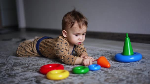 Schöne Friedliche Kleinkind Liegt Auf Dem Teppich Mit Spielzeug Vor — Stockvideo