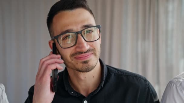 Brunet Man Met Een Bril Met Telefoon Aan Zijn Oor — Stockvideo