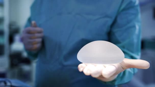 Nieznany Lekarz Trzymający Implant Piersi Dłoni Chirurg Demonstruje Materiał Obracający — Wideo stockowe