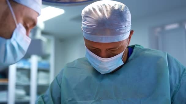 戴口罩的穿着制服的医生工作努力 在现代诊所的程序专业医疗人员 模糊的背景 — 图库视频影像