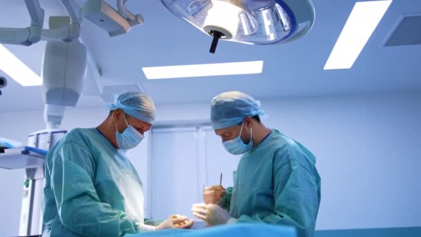 Dwóch Współpracujących Chirurgów Pracujących Nowoczesnej Sali Operacyjnej Lekarze Kończą Zabieg — Wideo stockowe