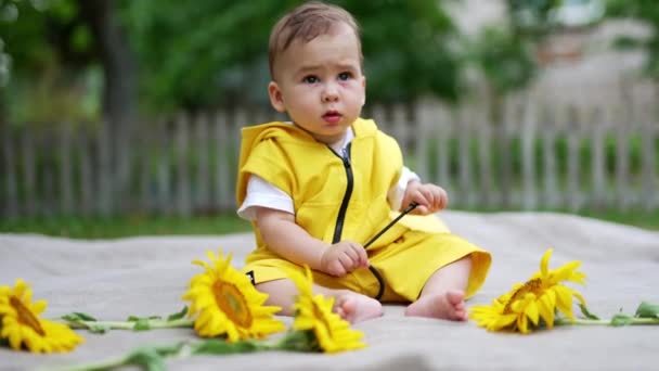 Uroczy Maluch Żółtych Ubraniach Siedzący Świeżym Powietrzu Naturze Uroczy Dzieciak — Wideo stockowe