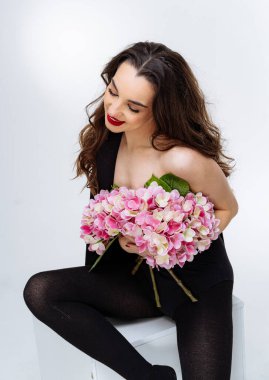 Çiçek buketi olan güzel genç bir kadın..