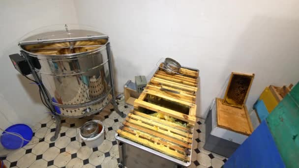 働く蜂蜜の抽出機械が付いている小部屋 遠心分離機の横にポンプを送るのを待っているフレームの大きい金属箱 高角度ビュー — ストック動画