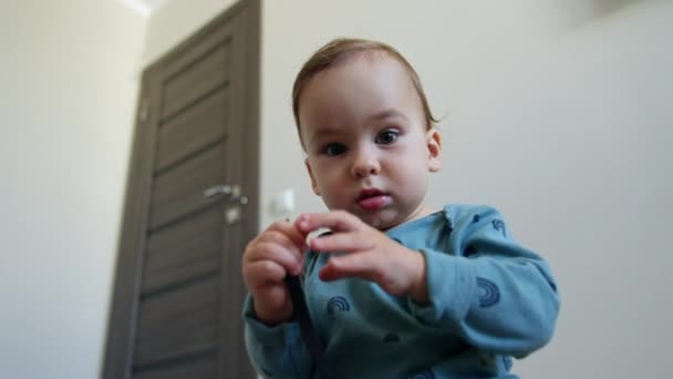 Mavi Tişörtlü Bebek Elinde Ayakkabı Bağcığına Merakla Bakıyor Şirin Çocuk — Stok video