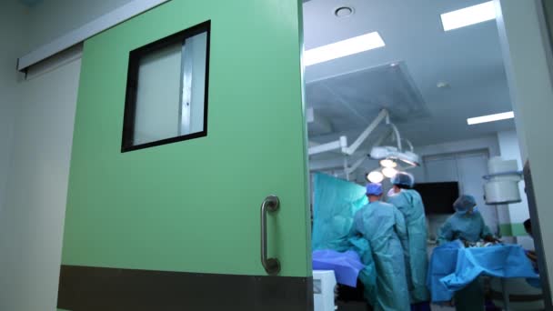 ドアの映像は手術手順を踏まえた手術室に開放された 医師はランプの明るいライトの下で働きます — ストック動画