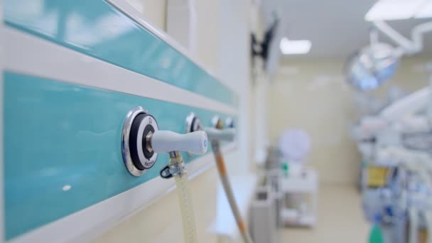 外科室の壁のパネルに接続されたチューブ 現代の病院で多様な設備を備えた空の操作劇場 ブラーレッド バックドロップ — ストック動画