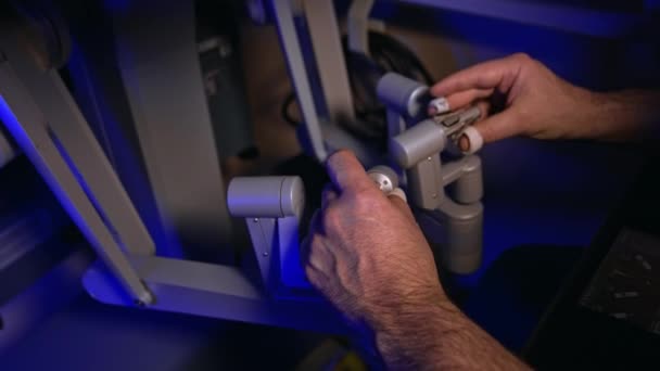 男性の手は外科室で未来的なロボット装置のハンドルを動かします 技術的な外科ロボットを運用しています クローズアップ トップビュー — ストック動画