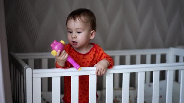 여자의 침대에 아기에게 장난감을 달콤한 아기는 장난감을 가지고 그것을 올립니다 — 비디오