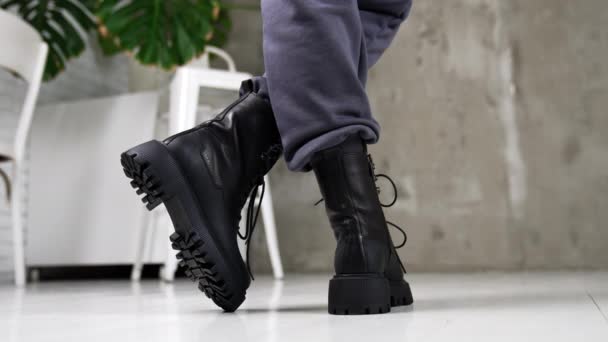 ブラックレースの軍用ブーツデモ クローズアップ スタジオで灰色のズボンと革の巨大な靴を身に着けているモデル — ストック動画
