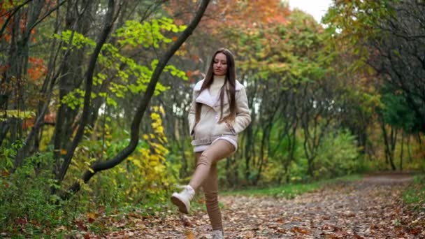 Uvolněná Dlouhosrstá Bruneta Házející Spadané Listí Cestě Uklidňující Krok Podzimním — Stock video