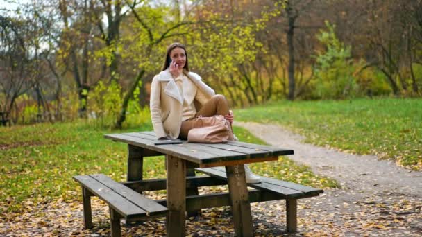 Dřevěném Stole Parku Sedí Běloška Béžových Šatech Žena Dívá Telefon — Stock video