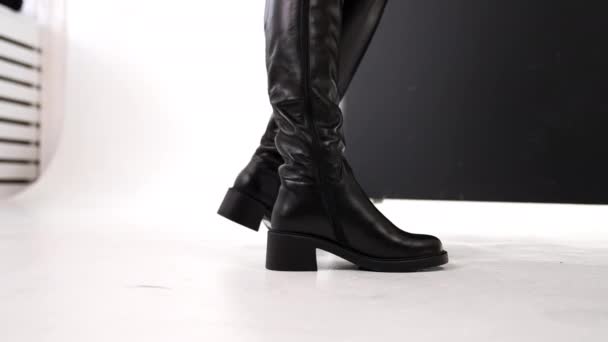 高黑色皮革女靴 中等高度高跟鞋 雅致的鞋类展示在工作室 靠近点白色背景 — 图库视频影像