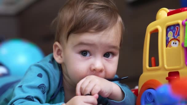 Miúdo Caucasiano Engraçado Está Chão Mastigar Laço Preto Adorável Bebê — Vídeo de Stock