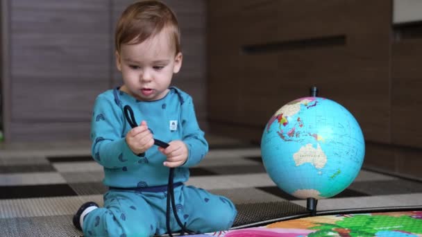 Schöne Baby Blauer Kleidung Sitzt Auf Dem Boden Und Hält — Stockvideo