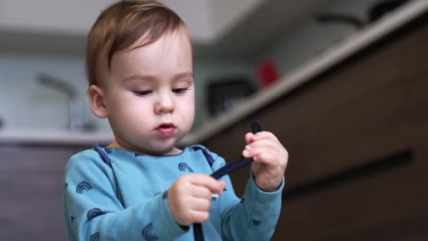 Mavi Gömlekli Sevimli Bebek Elinde Bir Kabloyla Meşgul Çocuk Mutfakta — Stok video