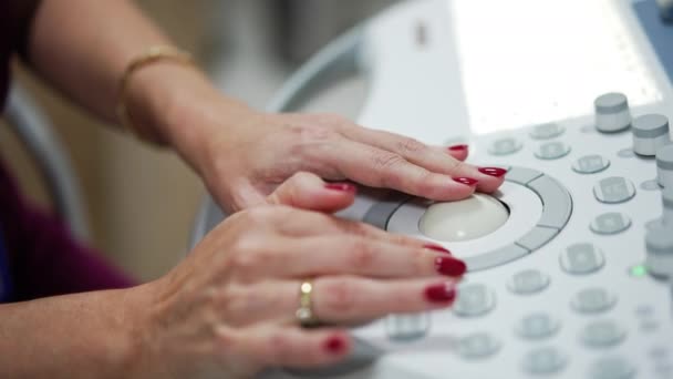 赤いマニキュアとリングを持つ大人の女性の手は 機器パネル上のボタンを管理します クローズアップ 超音波マシンに取り組む医学 — ストック動画