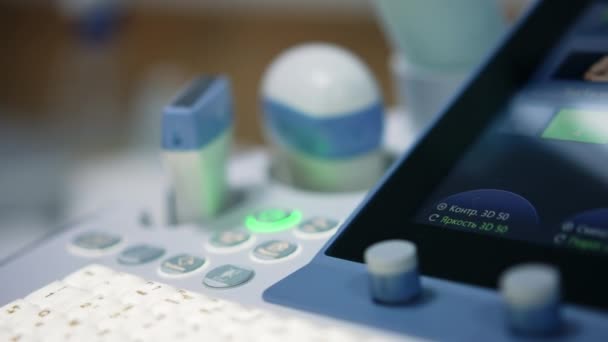 近代的な診療所の医療機器のキーとボタンを詳しく見てください 超音波診断機について ブラーレッド バックドロップ — ストック動画