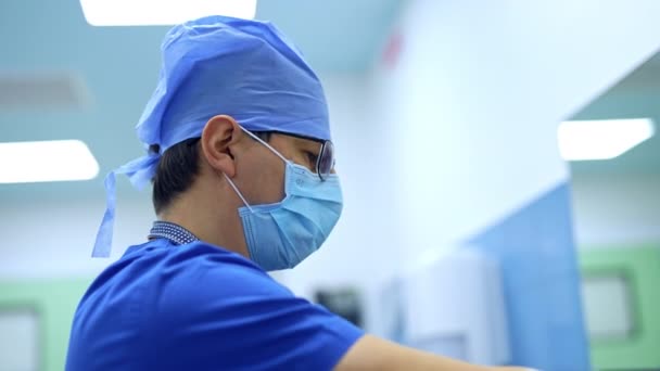 マスク メガネ キャップを着用した男性外科医は慎重に手を洗います 外科手術の準備をする専門家 — ストック動画