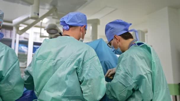 Uniformovaní Lékaři Čepicích Maskách Stojí Zády Kameře Chirurgové Spolupracující Při — Stock video