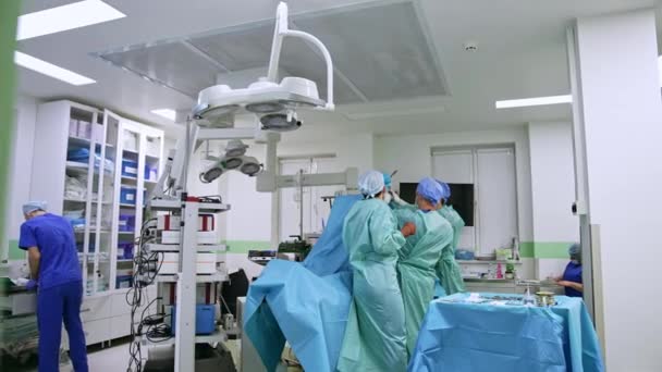 Trzech Lekarzy Współpracujących Przy Operacji Chirurgicznej Opuszczenie Nowoczesnej Sali Operacyjnej — Wideo stockowe
