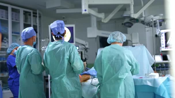 Grupo Cirujanos Trabajando Sala Cirugía Moderna Jefe Médico Usando Dispositivo — Vídeo de stock
