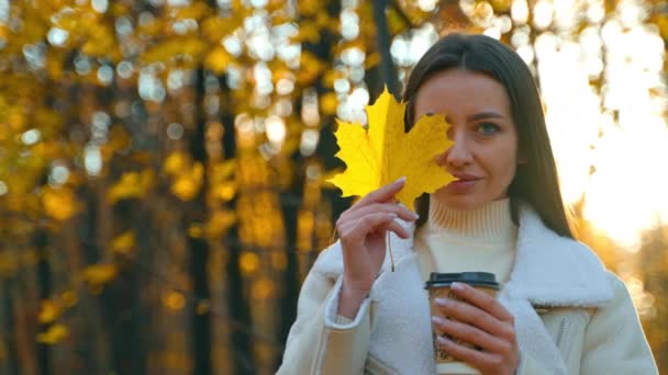 Krásná Dáma Papírovým Kelímkem Ruce Zakrývajícím Polovinu Obličeje Žlutým Javorovým — Stock video