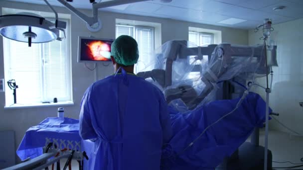 Konzentriert Steht Der Arzt Operationssaal Und Blickt Auf Den Bildschirm — Stockvideo