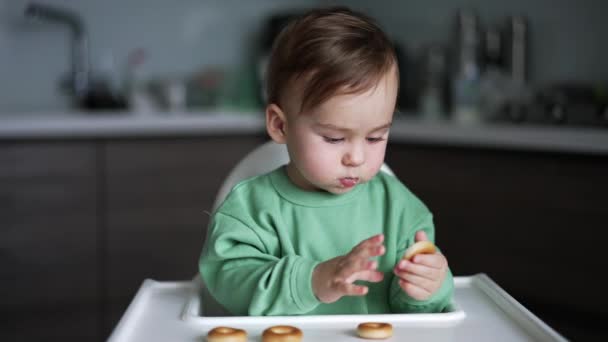 Een Lief Kind Aan Eettafel Neemt Een Bagel Die Voor — Stockvideo