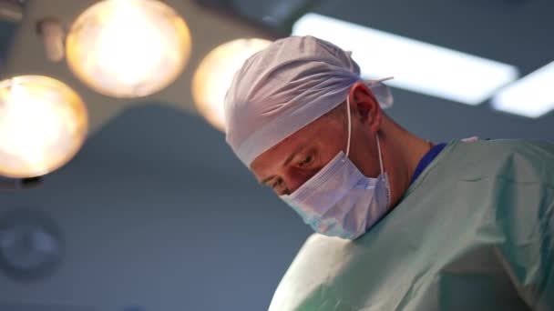 Médico Focado Máscara Tampa Trabalhando Sala Cirurgia Sob Lâmpadas Brilhantes — Vídeo de Stock